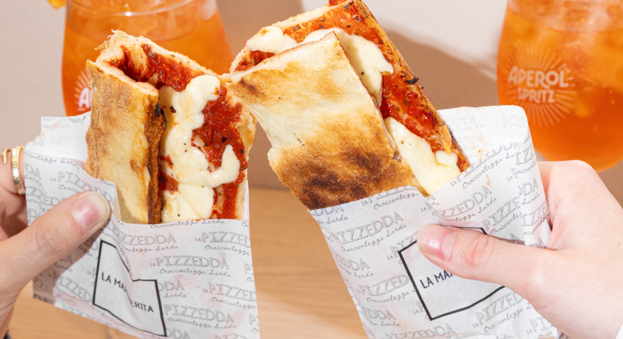 Cosa fare a Porta Venezia: una pizzedda croccante di Sa Pizzedda davanti ai palazzi storici del quartiere di Milano.